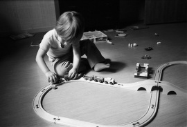little boy playing with a toy train